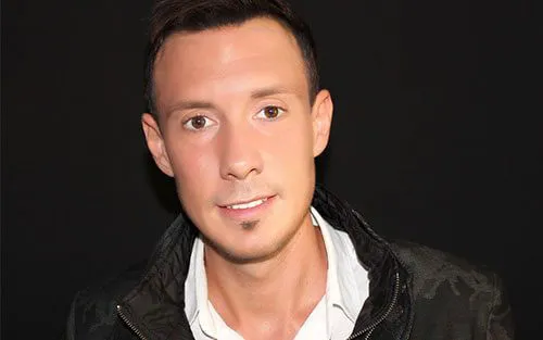Porträt von Torben Platzer, Unternehmer und Herausgeber des Selfmade Kurses, vor dunklem Hintergrund