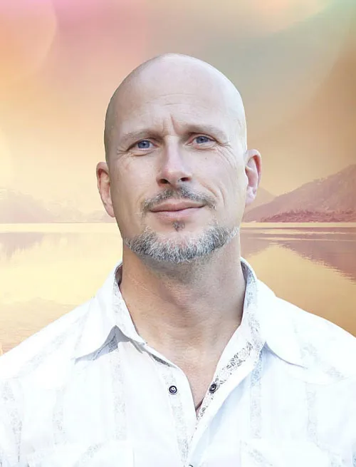 Andreas Goldemann im weißen Hemd vor einer pastellfarbenen Seelandschaft