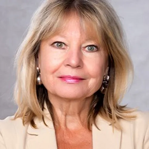 Porträt von Barbara Formann, Gründerin des Happy Aging Clubs, mit blonden Haaren vor grauem Hintergrund