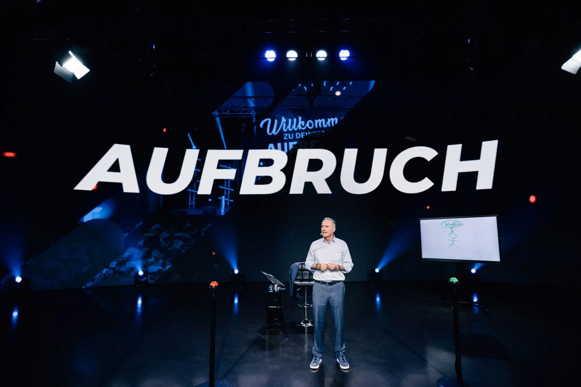 Bodo Schäfer auf der Bühne beim Seminar Aufbruch vor dem großen Schriftzug Aufbruch