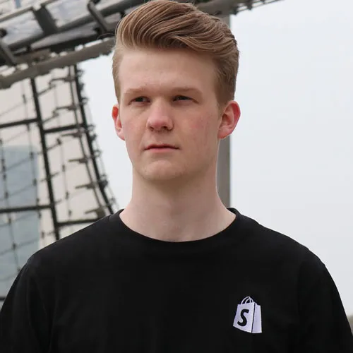 Porträt von ChrisFil (Christoph Filgertshofer) im schwarzen T-Shirt mit Shopify-Logo