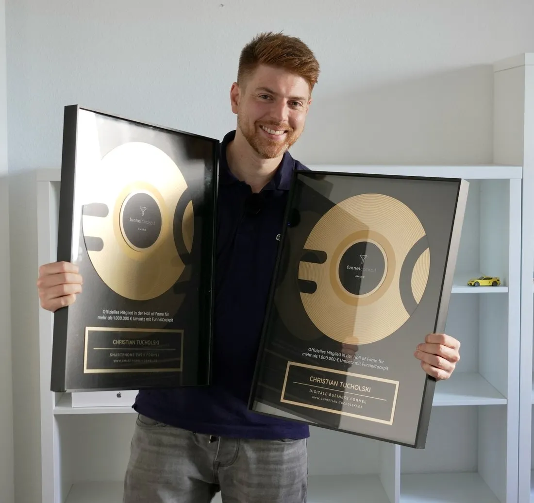 Christian Tucholski hält zwei gerahmte FunnelCockpit Awards für die Smartphone Cash Formel und die Digitale Business Formel