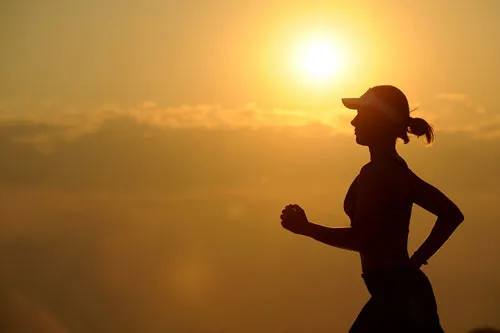Silhouette einer Joggerin vor der untergehenden Sonne als Symbol für die Workouts im MAXIMUMPRINZIP