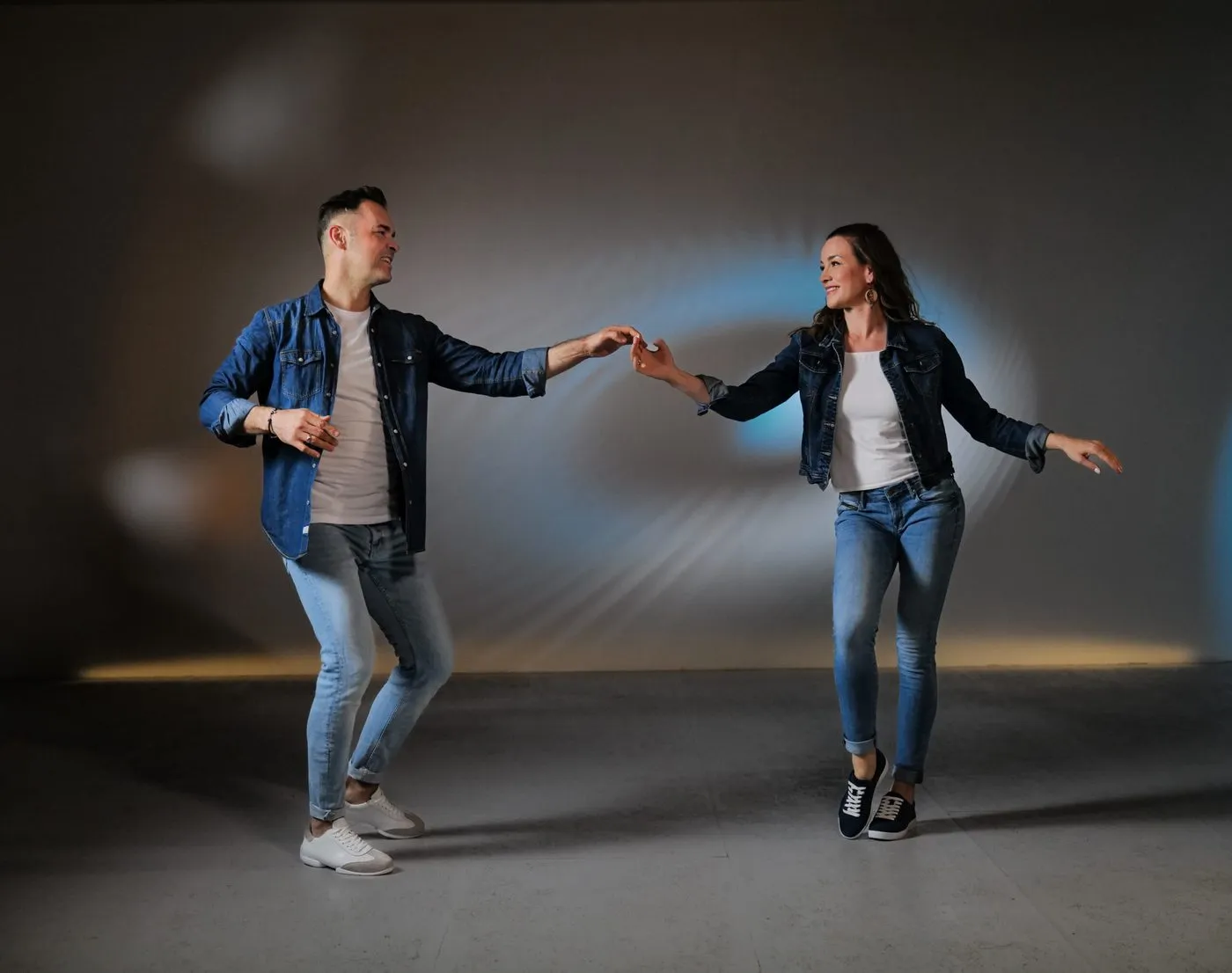 Conny und Dado Ibrakovic tanzen Hand in Hand in einem hellen Studio