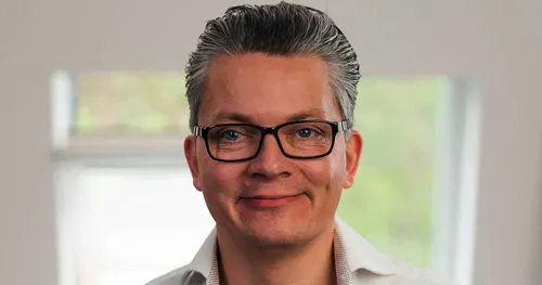 Porträt von Damian Richter mit Brille und grauen Haaren