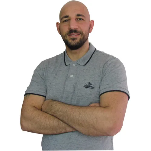 Darek Shabany im grauen Poloshirt mit verschränkten Armen