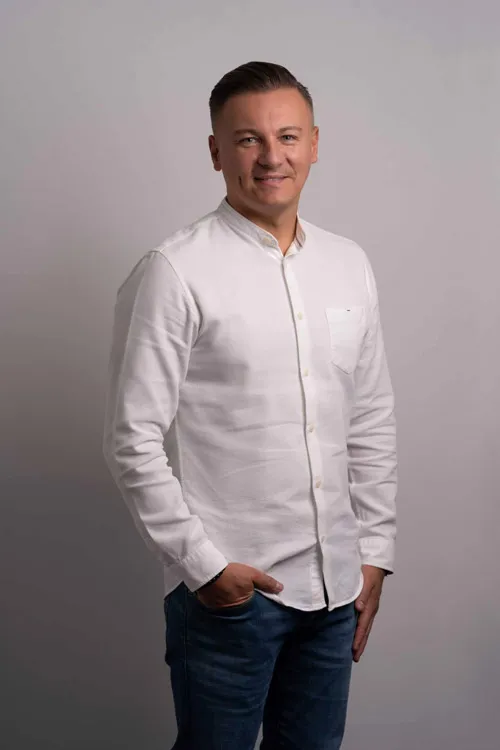 Dawid Przybylski im weißen Hemd vor grauem Hintergrund