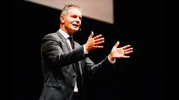 Dirk Kreuter hält mit ausgebreiteten Händen einen Vortrag auf der Bühne