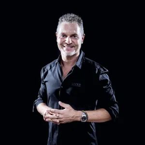 Dirk Kreuter im schwarzen Hemd vor schwarzem Hintergrund