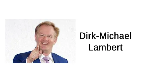 Dirk-Michael Lambert zeigt lächelnd mit dem Finger nach vorne neben dem Schriftzug Dirk-Michael Lambert