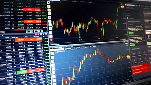 Börsenkurse und Kerzencharts auf mehreren Monitoren als Symbol für die Dividendenstrategie