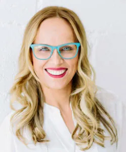 Porträt von Dr. Natalia Wiechowski mit langen blonden Haaren und türkiser Brille