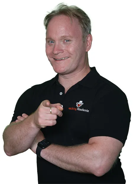 Eric Amberg im schwarzen Poloshirt der Hacking Akademie zeigt mit dem Finger nach vorn