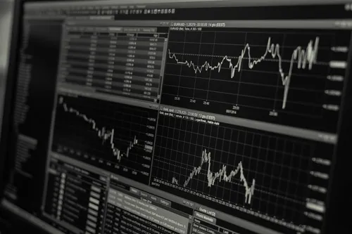 Schwarz-weißer Monitor mit mehreren Aktiencharts und Kurstabellen
