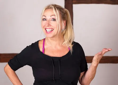 Pilates-Lehrerin Gabriela Höper lacht im schwarzen Sportshirt in die Kamera
