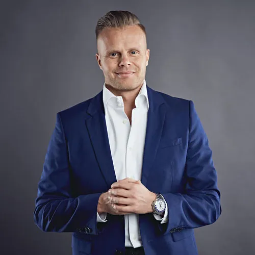 Gunnar Kessler im blauen Sakko mit weißem Hemd vor grauem Hintergrund