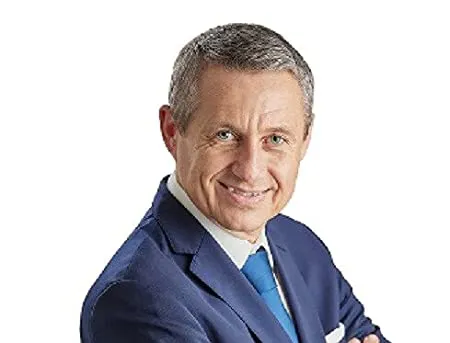 Porträt des lächelnden Forex-Experten Jürgen Wechsler im blauen Anzug mit Krawatte
