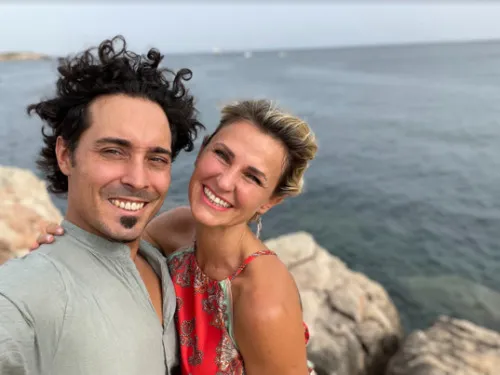 Selfie von Claudio und Karo lachend vor Felsen am Meer