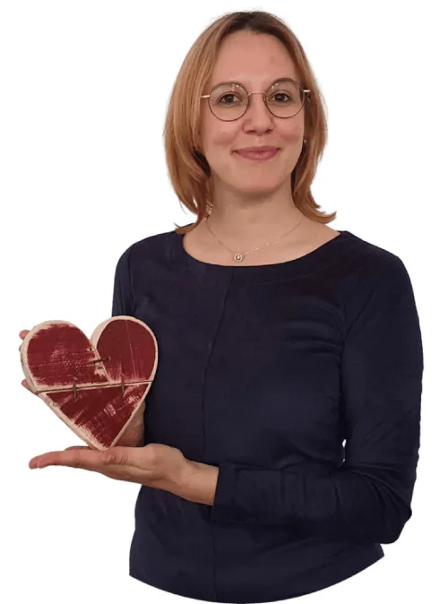 Lena Kager von Szenario-Zwei hält ein rotes Herz aus Holz in der Hand