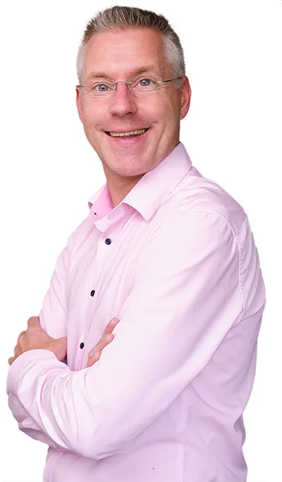 Steuerberater Lutz Spieker im rosa Hemd mit verschränkten Armen