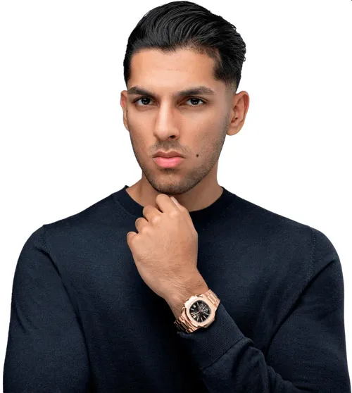 Porträt von Manjeet Singh Sangha im dunkelblauen Pullover mit Uhr, die Hand am Kinn