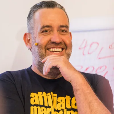 Ralf Schmitz lachend mit Headset-Mikrofon und Affiliate-Marketing-Shirt