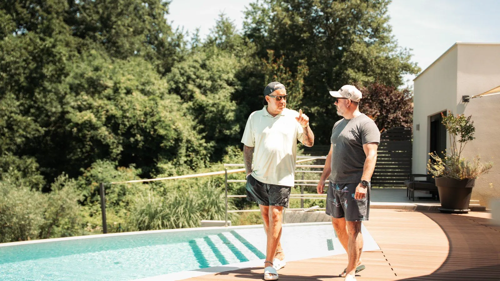 Ralf Schmitz und Adrian Giger im Gespräch an einem Pool