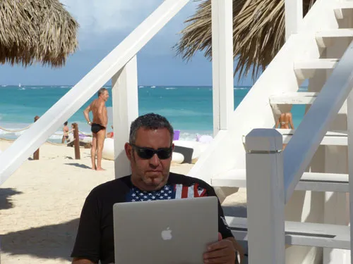 Ralf Schmitz sitzt mit Laptop am Strand von Mallorca