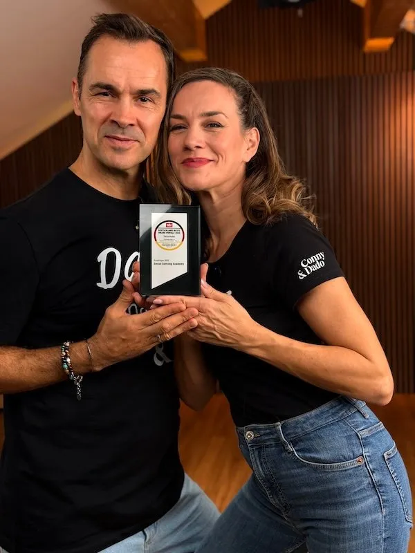 Conny und Dado Ibrakovic halten die Plakette Deutschlands beste Online-Portale 2025 in die Kamera