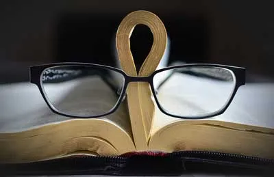 Brille auf einem aufgeschlagenen Buch als Symbol für Speed Reading online lernen im Videokurs