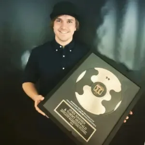Sven Hansen hält eine gerahmte goldene Schallplatte mit Auszeichnung für Sven Hansen und Tommy Seewald