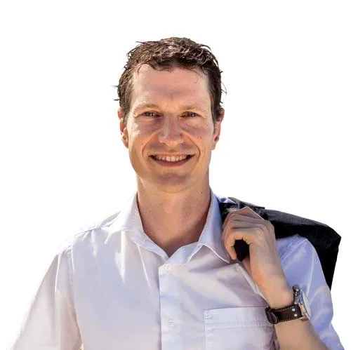 Thorsten Wittmann lächelnd im weißen Hemd mit Sakko über der Schulter