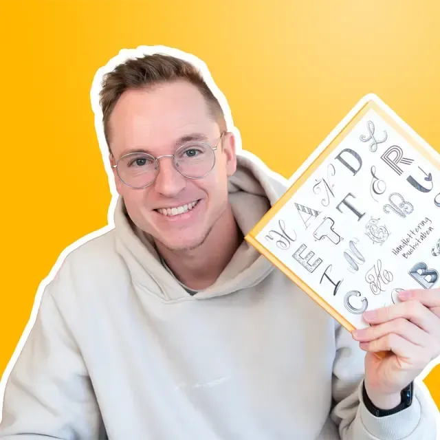 Timo Ostrich hält lächelnd ein Buch vor gelbem Hintergrund