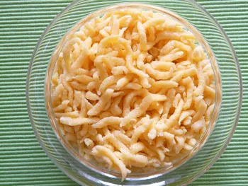 Glasschüssel mit selbstgemachten veganen Spätzle auf grün gestreifter Tischdecke
