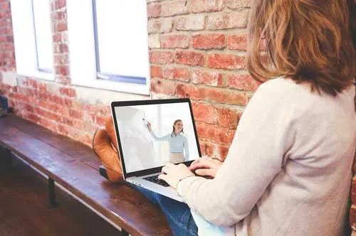 Frau am Laptop verfolgt ein Webinar, das über Instagram beworben wird