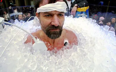 Wim Hof, der Iceman, sitzt mit Stirnband und Messsensoren bis zum Hals in Eiswürfeln