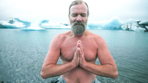 Wim Hof mit nacktem Oberkörper und gefalteten Händen vor einer Gletscherlandschaft
