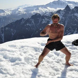 Wim Hof in Shorts barfuß im Schnee vor einem Bergpanorama