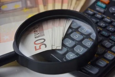 Lupe über Euro-Geldscheinen und Taschenrechner zur Preis-Leistung im YouTube Expert Programm Erfahrungsbericht